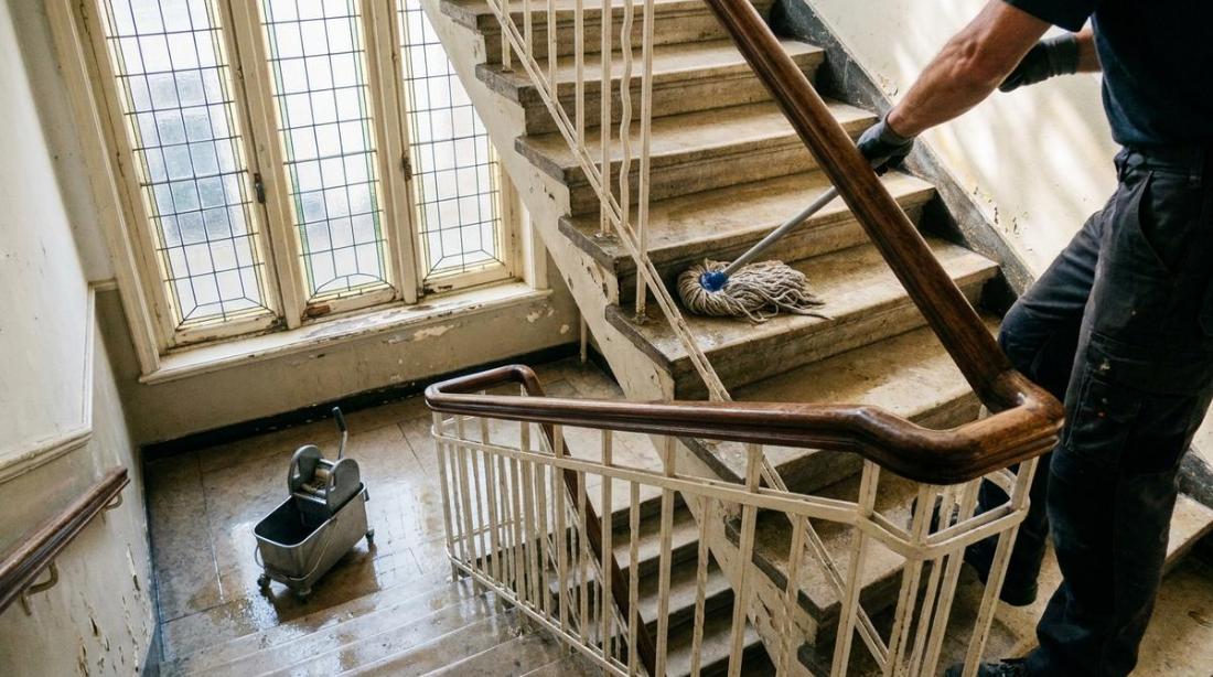 Een stofzuiger op een houten trap, van bovenaf gezien