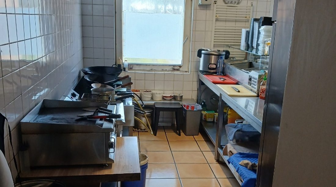 Stainless steel extractor hood with baffle filters above a restaurant cooking line