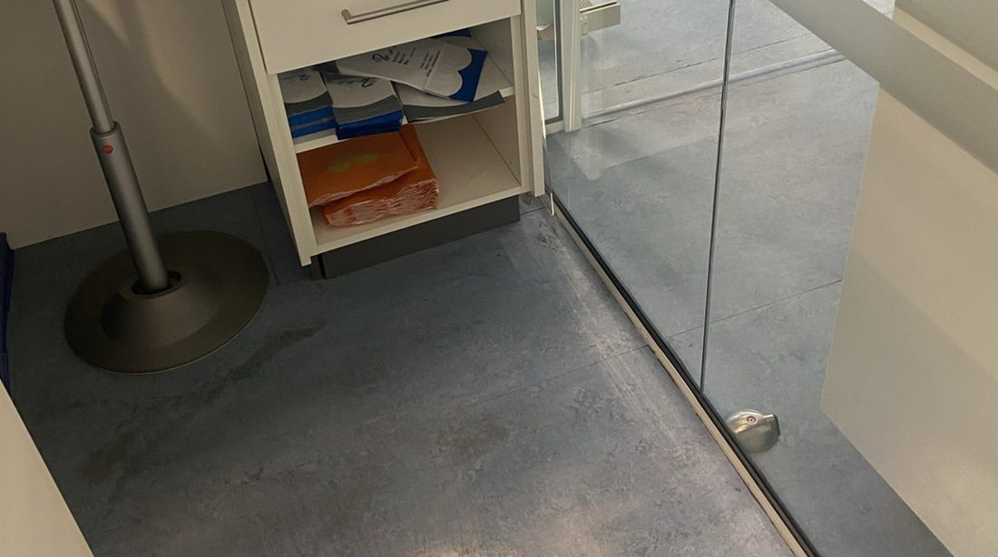 Een glazen scheidingswand en een schone harde vloer in een kantoor