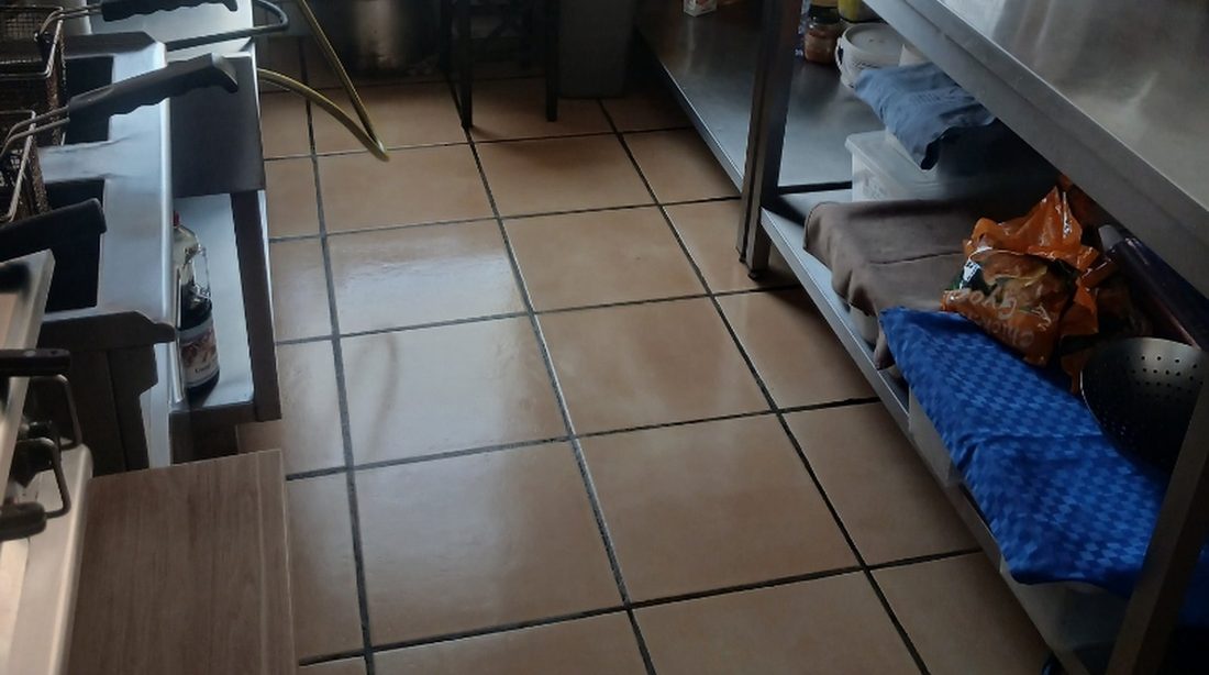 Een keukenlijn in een restaurant op rode plavuizen met donkere voegen