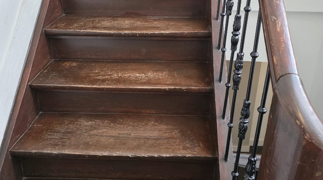 Varnished wooden stairs with an iron banister in an old Maastricht building