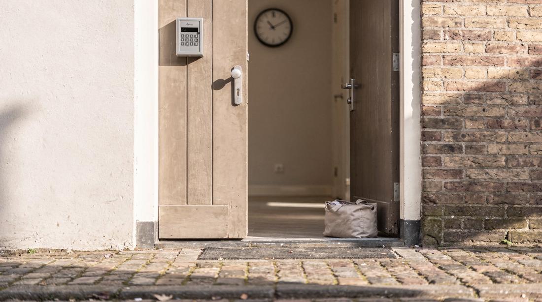 Deuropening van een appartement met sleutelkluisje en een gevouwen waszak bij een wissel op dezelfde dag