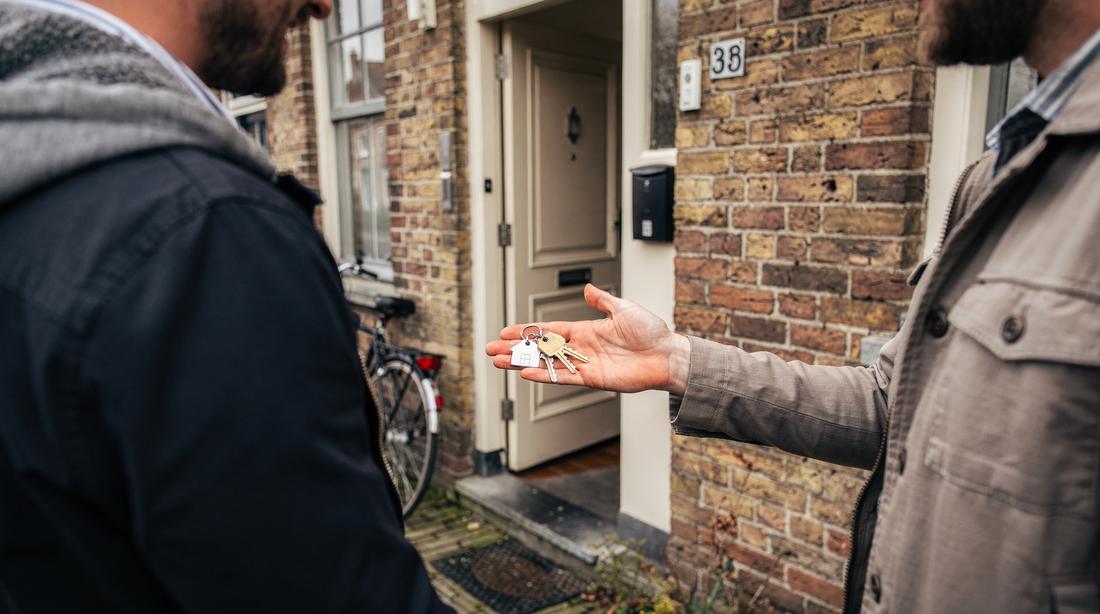 Keys being handed over at the front door of a Maastricht brick terraced house