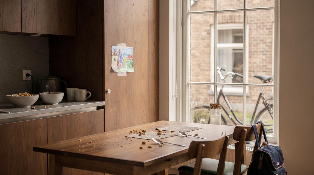 Drukke Nederlandse gezinskeuken net na het ontbijt, schaaltjes en mokken op het werkblad