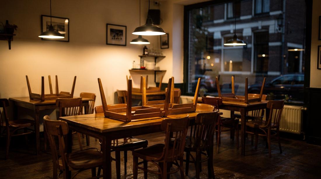 Restaurantzaal gereset na sluiting, stoelen op tafels en de vloer net gedweild