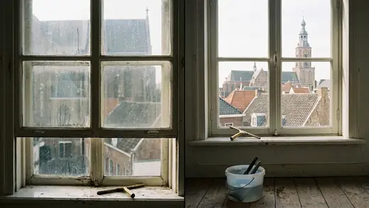 A tall window over Maastricht's rooftops, the bucket ready below