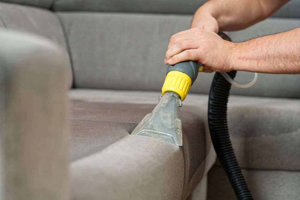 Hot-water extraction lifting dirt out of a sofa seat