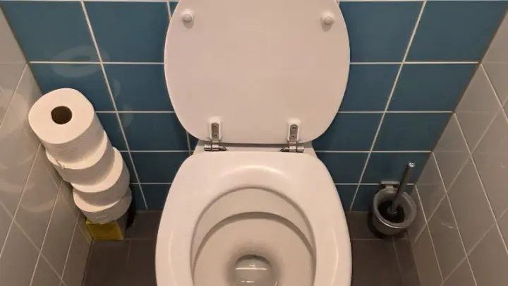 A toilet against blue wall tiles