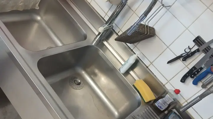 Een betegelde keukenwand en rvs-spoelbakken