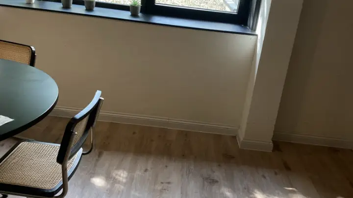 A living-room corner by the window, wooden floor