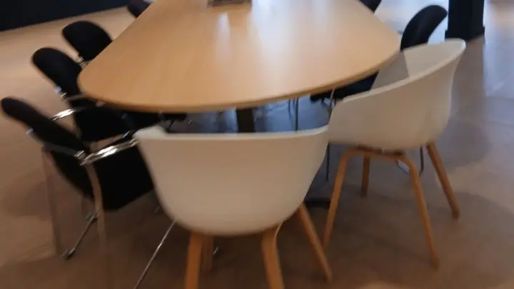 A round table with white chairs