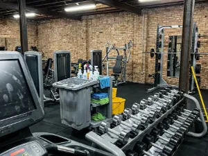 A gym with the cleaning trolley between the weights