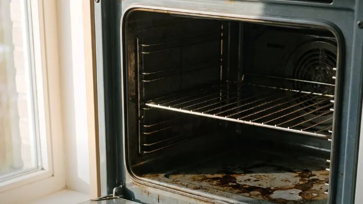 Burnt-on grease inside an oven, the door open