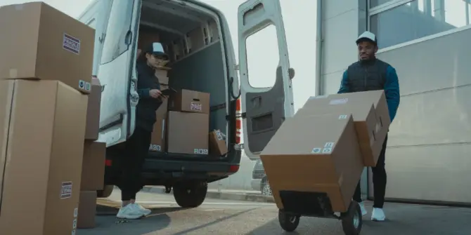 a man and woman loading boxes into a van