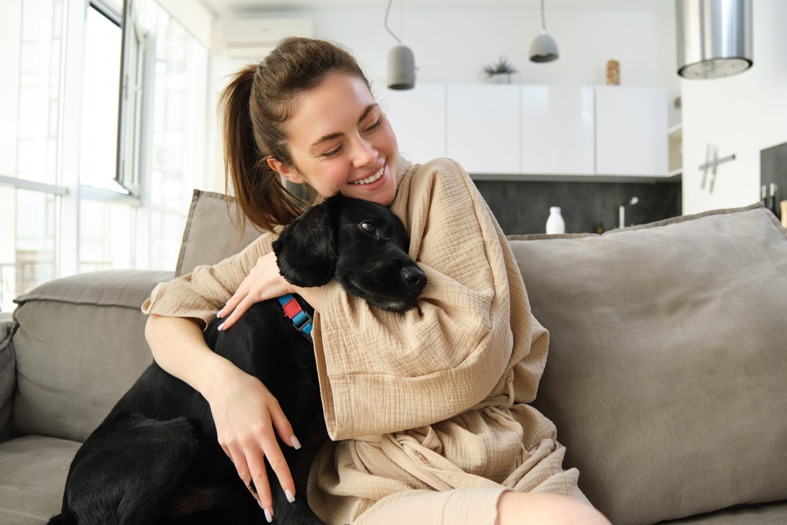 Dog Care Services 2 a woman sitting on a couch with a dog