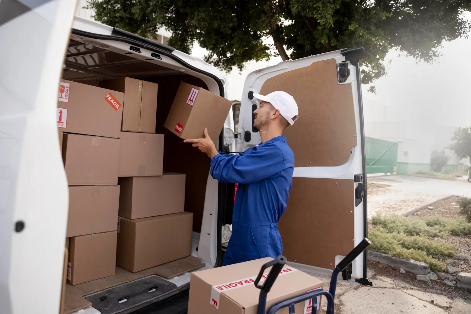 a man in a blue uniform loading boxes into a van